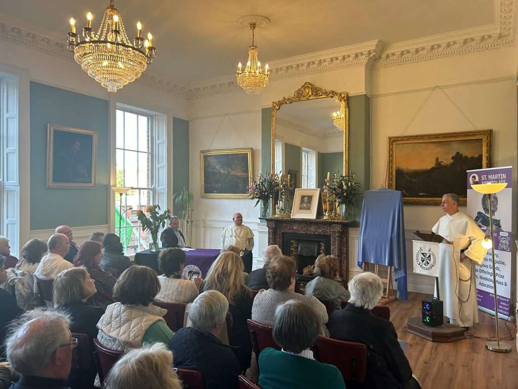 Presentation event in Room No. 42 honouring the Legion of Mary by the Dominicans Room No. 42 during an event showing a presentation of a picture to the Legion of Mary by the Dominicans, with attendees seated and focused on the front.